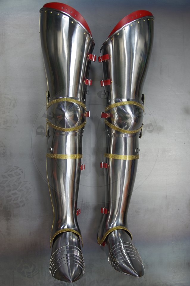 English style leg harness with fully closed cuisses, full greaves with characteristic line around outside ankles. Demi-greaves connected with greaves on rotary pin. Made of medium carbon steel of various thickness from 1 mm up to 1,5 mm. Heat hardened and tempered up to 42 HRC. Brass bands decoration motive based on example visible on Henry V tournament helm. Hand made steel buckles in set./Osony ng w stylu angielskim z w peni zamknitymi nabiodrkami, nagolennicami z charakterystyczn lini wok zewntrznej kostki. Demi-greave poczony z nagolennicami poprzez obrotowy pin. Wykonane ze stali redniowglowej rnej gruboci od 1 mm do 1,5 mm. Hartowane i odpuszczane do 42 HRC. Mosine listwy dekoracyjne z motywem wzorowanym na hemie turniejowym Henryka V. W zestawie rcznie robione sprzczki stalowe.